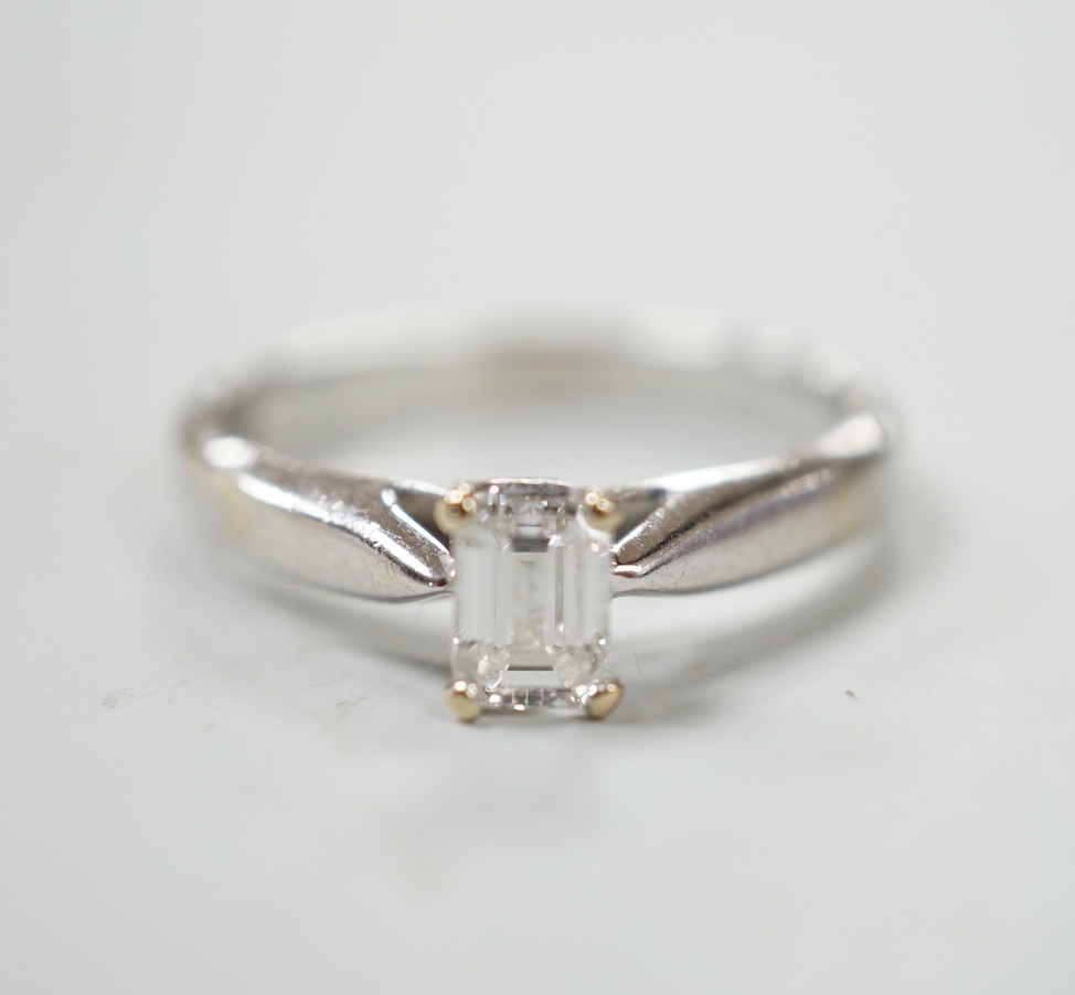 A 750 white metal and solitaire emerald cut diamond ring, size J/k, gross weight 2.9 grams.